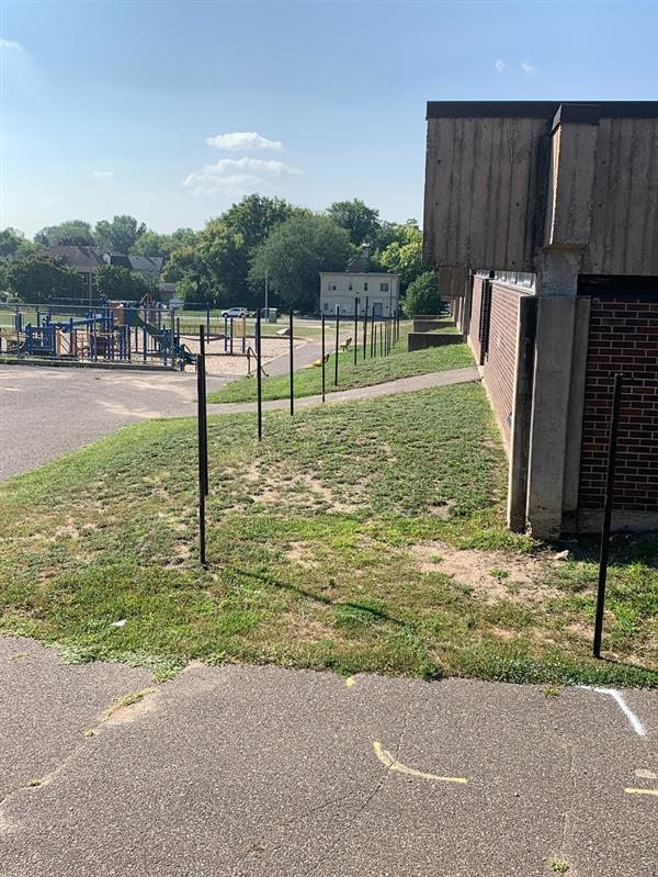 Posts placed for fencing along east side of school to separate construction from the school